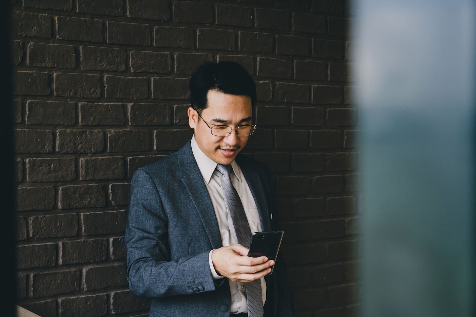 happy-asian-businessman-using-smart-phone-2021-09-04-09-57-06-utc.jpg