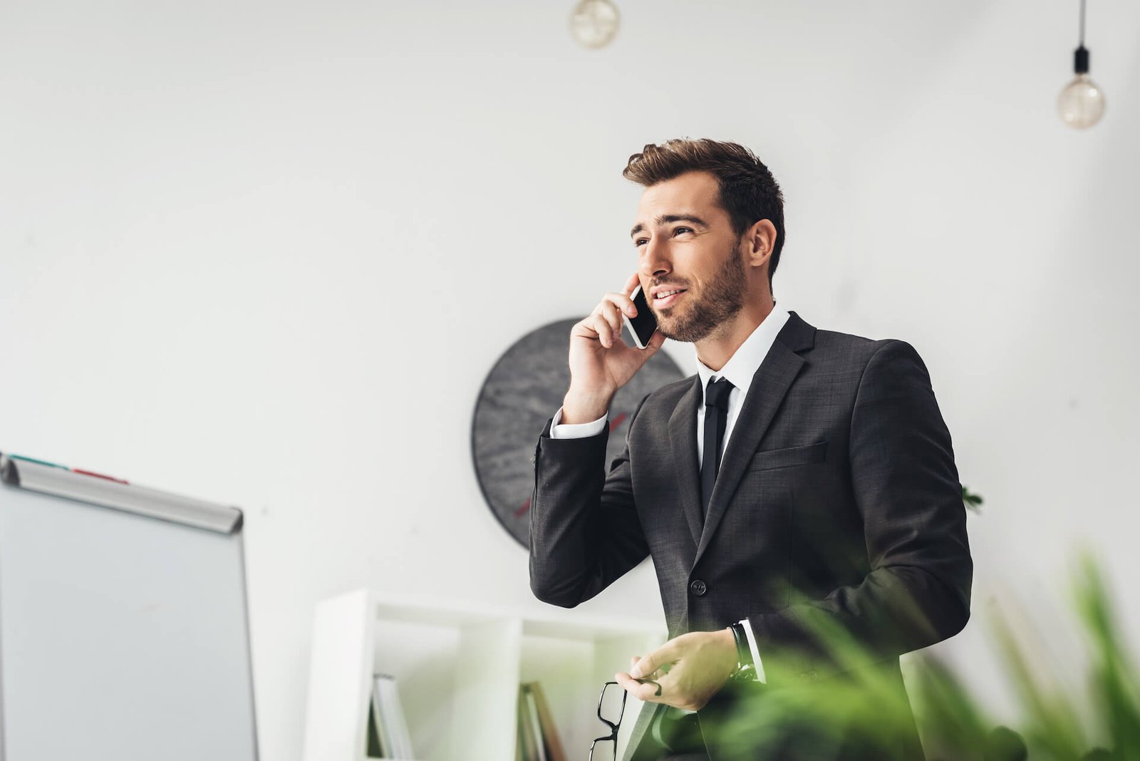 happy-young-businessman-talking-by-phone-in-office-2021-08-29-17-03-22-utc.jpg