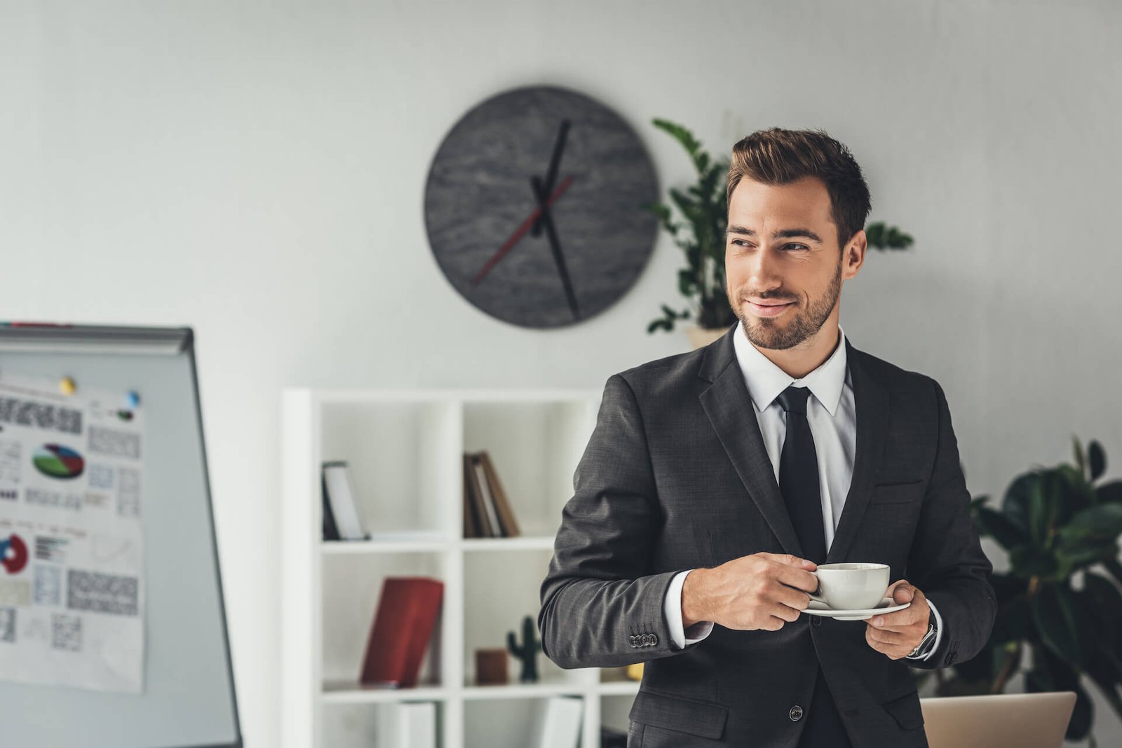 happy-young-businessman-with-cup-of-coffee-at-offi-2021-08-31-22-17-08-utc.jpg
